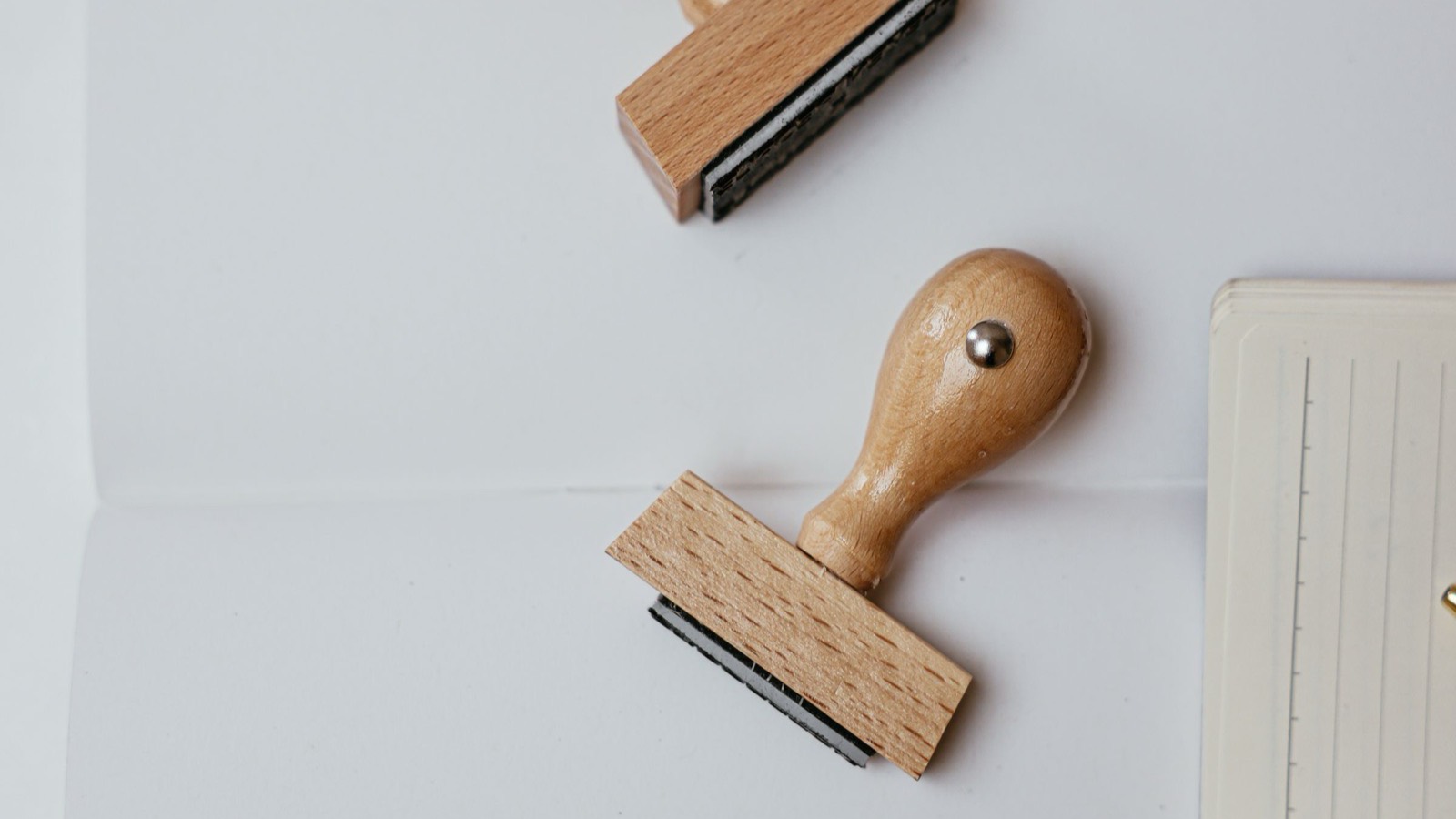 Stempel kayu dan buku catatan di atas kertas putih